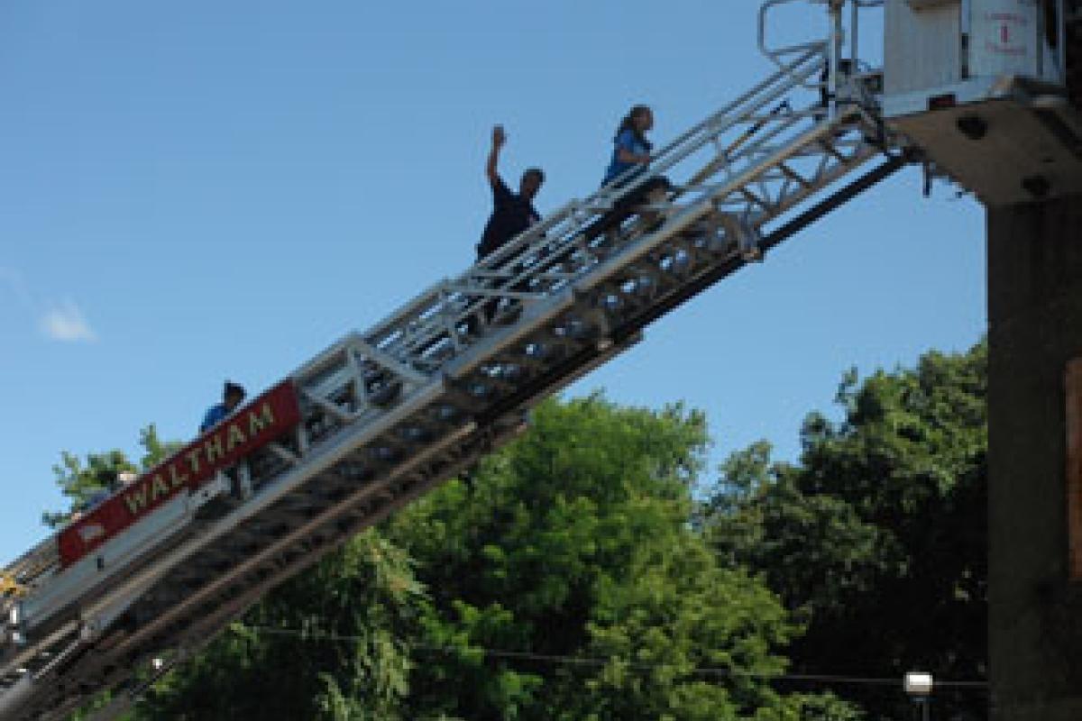Campers Climb Aerial Ladder with Fire Fighter's assistance